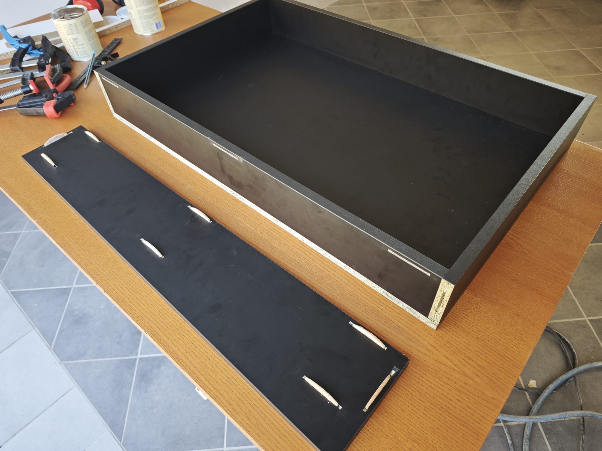 Assembled black box of the dartR Vulcano dartboard section on a workbench, with a separate drilled panel lying next to it