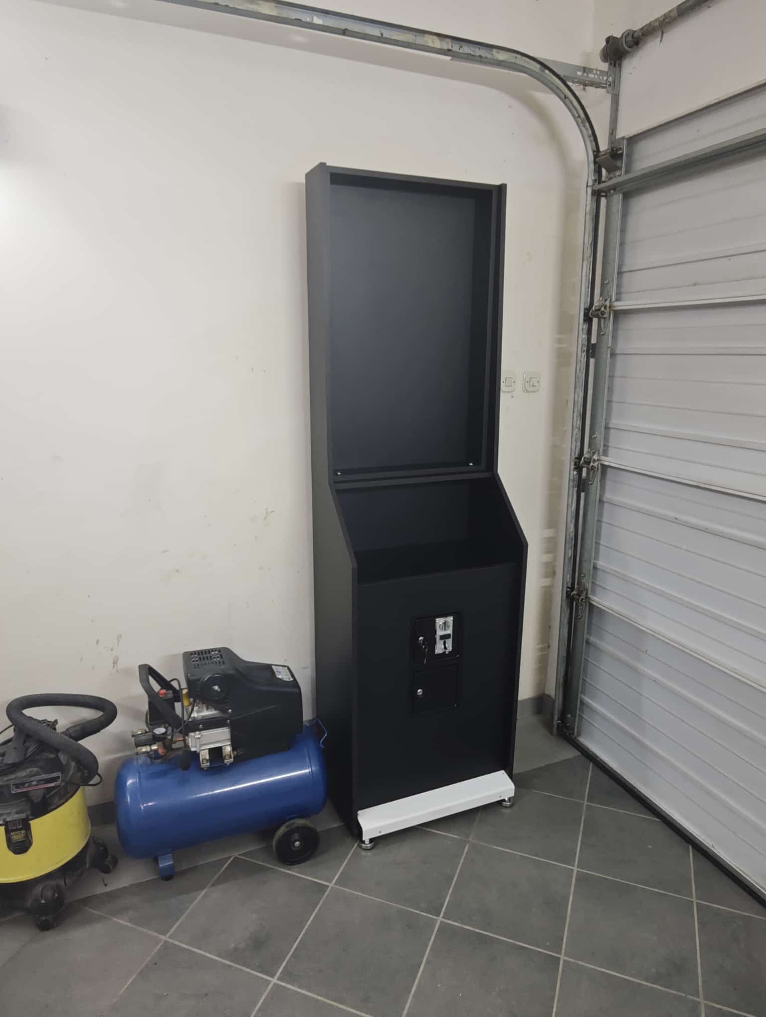 Wider front-left view of the assembled Vulcano base and dartboard sections in the garage
